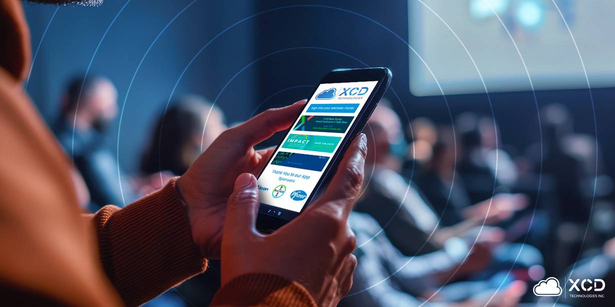 Person using X-CD Technologies' mobile event app with gamification features during a conference, with audience members seated in the background.